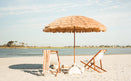 The Sirocco - Natural beach umbrella and lounge chairs on a sandy shore.