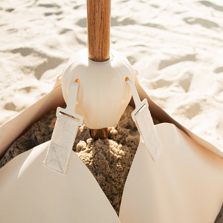 Natural Inspired beige umbrella base (the blossom base) filled with 100lbs of sand and the conch connector.