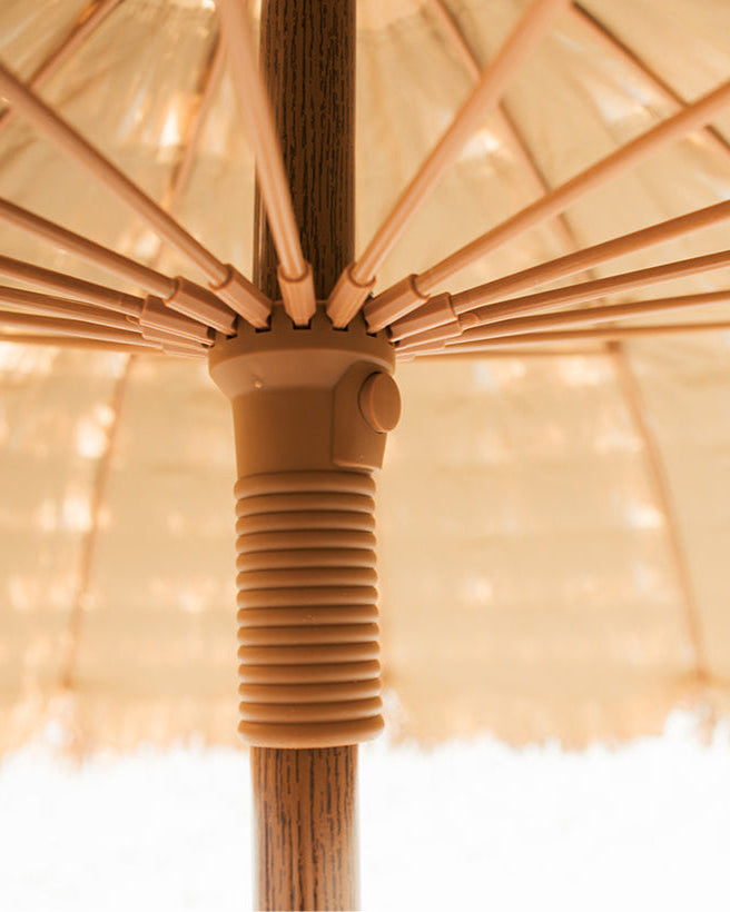 Close-up of a natural umbrella with a ribbed handle on a button release runner