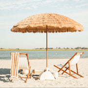 A natural beach umbrella and a luxury beach setup.
