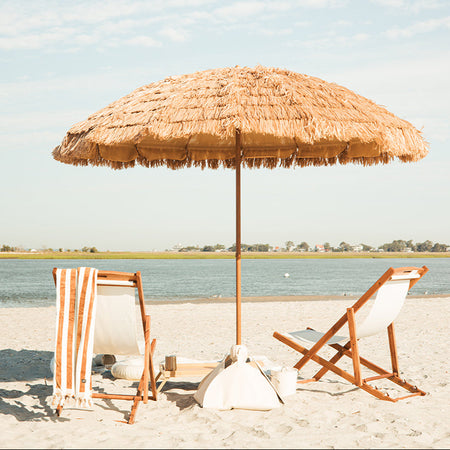 A natural beach umbrella and a luxury beach setup.