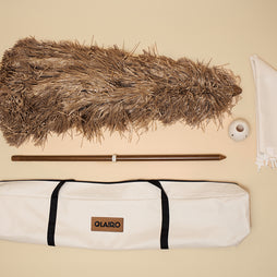 The Sirocco Beach umbrella and all included parts: The dried grass Canopy, The canvas carry bag, the conch connector, the blossom base, and the aged bamboo pole